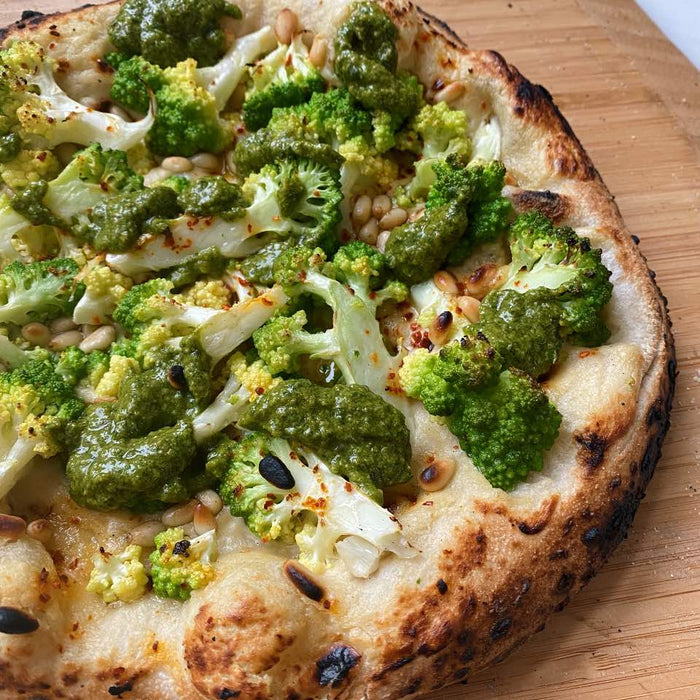 Pizza with creamy cashew cream base, topped with Romanesco cauliflower and a herby Mediterranean salsa verde