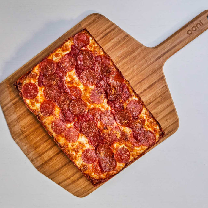 Detroit-style pizza with pepperoni on an Ooni Bamboo Peel & Serving Board.