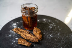 Chipotle chilies infusing in a glass jar of honey