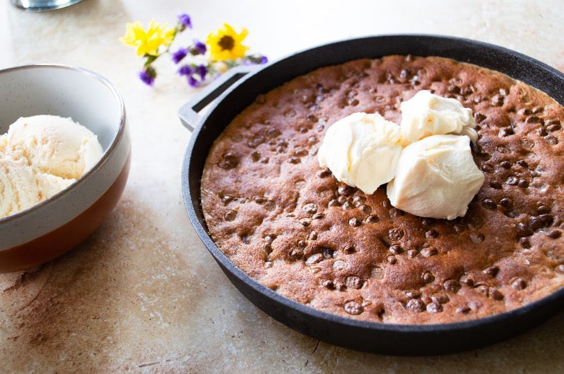 Chocolate chip cookie basked in an ooni cast iron skillet pan