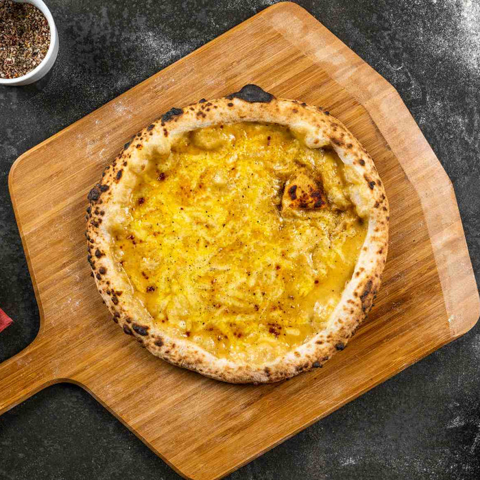 Welsh Rarebit Pizza served on a wooden pizza peel