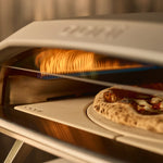  Close up of rotating stone cooking pizza. 