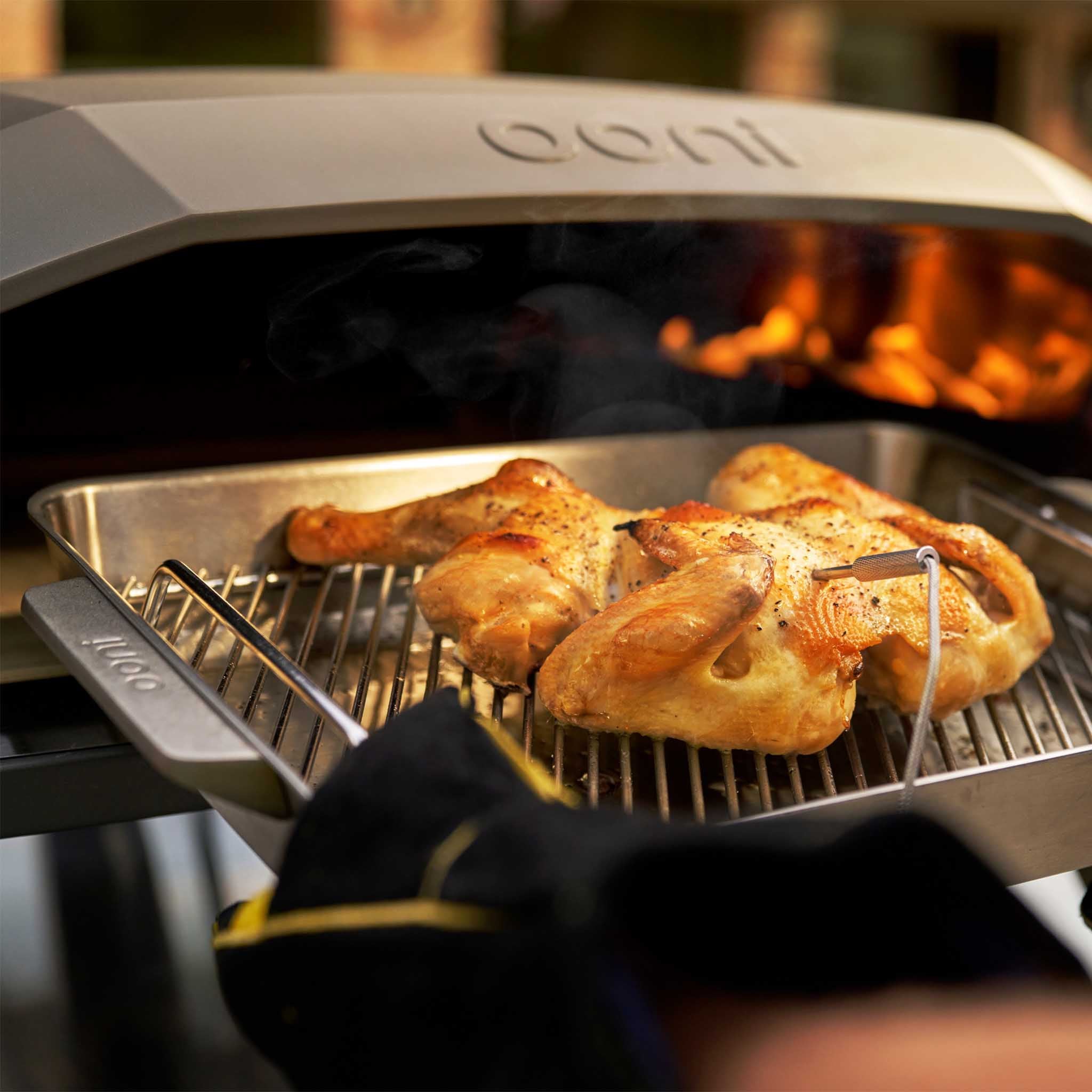Koda 2 Max gas powered pizza oven cooking a chicken in a roasting pan 
