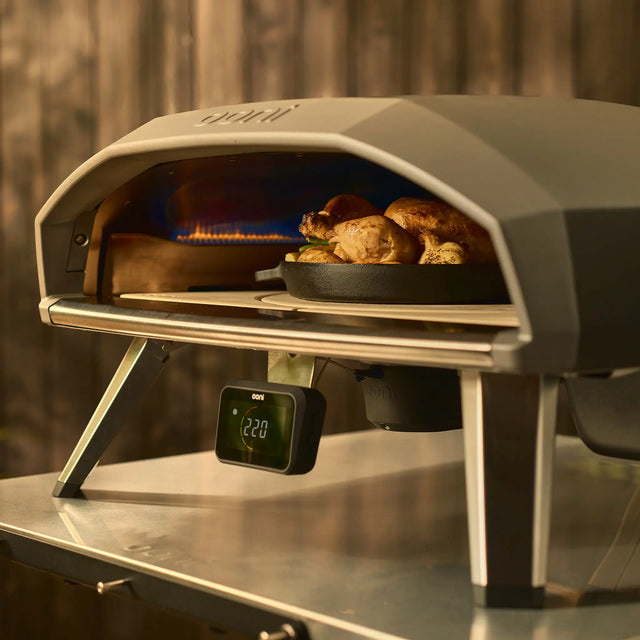 cast iron pan cooking chicken on the rotating stone in Koda 2 Pro 