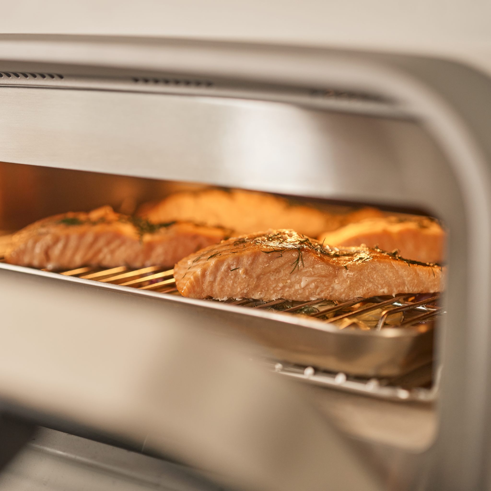 close up of salmon fillets cookiing on sheet pan and rack for ooni volt 2 