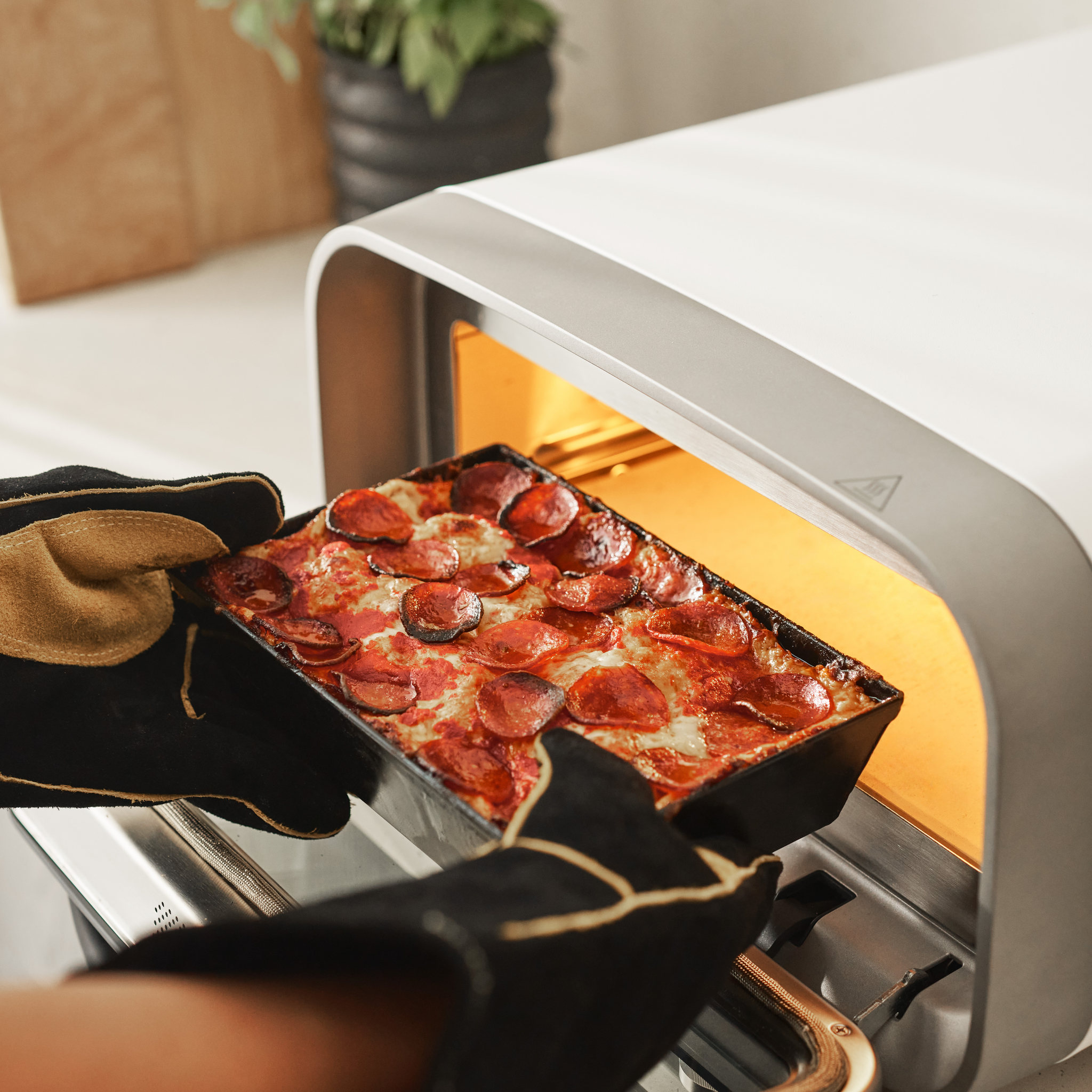 Detroit pan being retrieved from ooni volt 2 electric pizza oven
